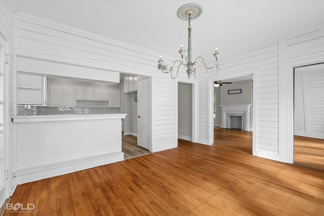 174 Carrollton Ave, Shreveport, LA 71105 - kitchen featuring a chandelier, light countertops, ceiling fan, a peninsula, and light wood-type flooring