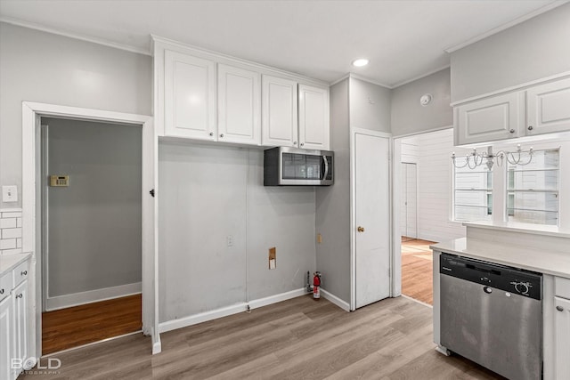 174 Carrollton Ave, Shreveport, LA 71105 - kitchen with appliances with stainless steel finishes, white cabinets, ornamental molding, light wood-style flooring, and light countertops