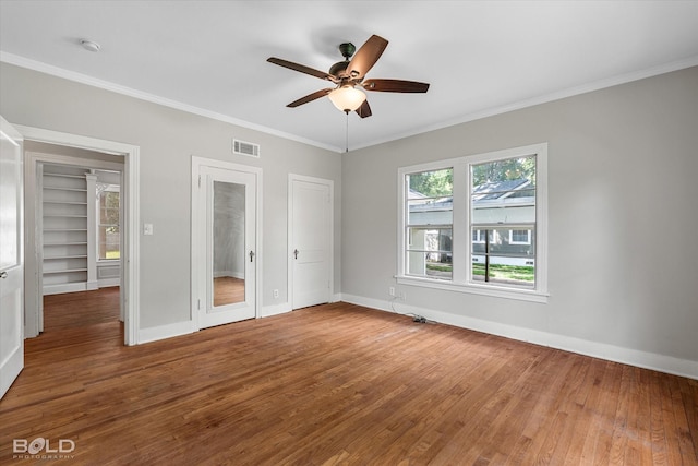 174 Carrollton Ave, Shreveport, LA 71105 - unfurnished bedroom featuring wood finished floors, ornamental molding, a ceiling fan, and multiple closets