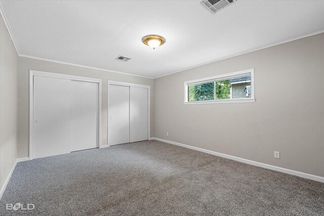 174 Carrollton Ave, Shreveport, LA 71105 - unfurnished bedroom featuring multiple closets, ornamental molding, and carpet flooring