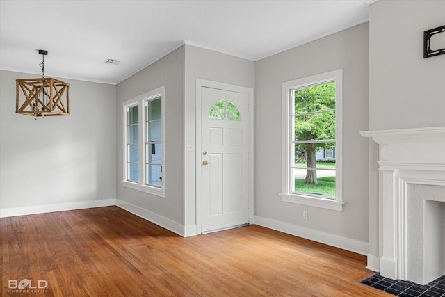 174 Carrollton Ave, Shreveport, LA 71105 - foyer entrance featuring a chandelier, light wood-style floors, crown molding, and a high end fireplace