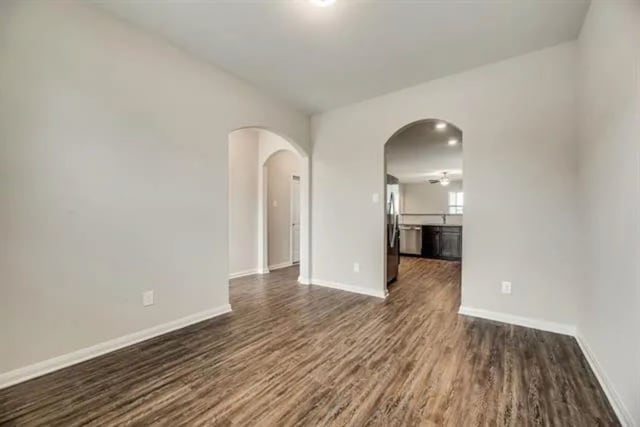 220 Aaron St, Anna, TX 75409 - spare room featuring arched walkways and dark wood finished floors