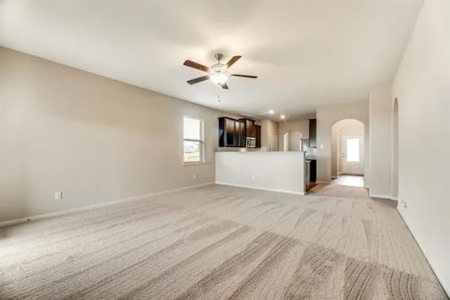 220 Aaron St, Anna, TX 75409 - unfurnished living room with arched walkways, a ceiling fan, and light colored carpet