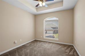 5729 Blackmon Ct, Fort Worth, TX 76137 - carpeted empty room with a ceiling fan and a tray ceiling