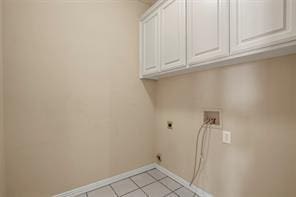 5729 Blackmon Ct, Fort Worth, TX 76137 - laundry room with cabinet space, electric dryer hookup, light tile patterned flooring, and washer hookup