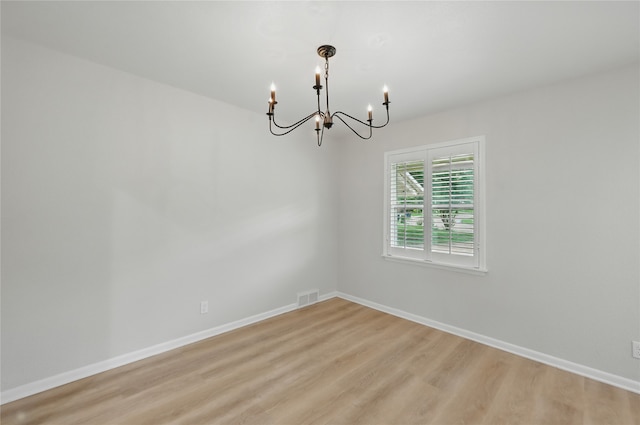 2705 Shelby St, Garland, TX 75041 - unfurnished room featuring a chandelier and light wood-style flooring