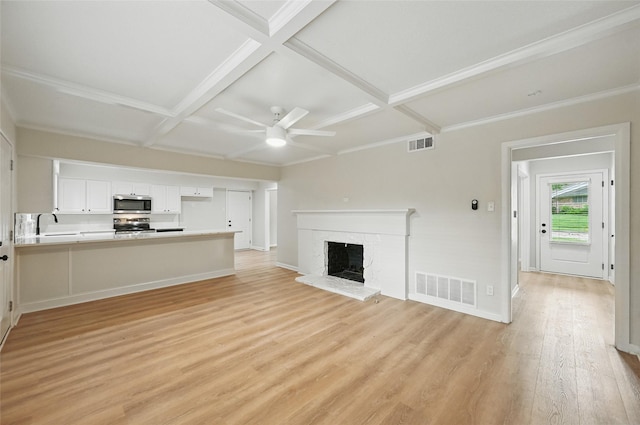 2705 Shelby St, Garland, TX 75041 - unfurnished living room featuring coffered ceiling, ceiling fan, light wood-style floors, a fireplace, and beamed ceiling