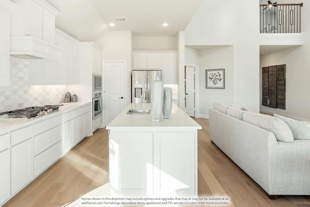 3803 Hidden Cove Ct, Rockwall, TX 75032 - kitchen featuring appliances with stainless steel finishes, open floor plan, tasteful backsplash, a center island with sink, and high vaulted ceiling