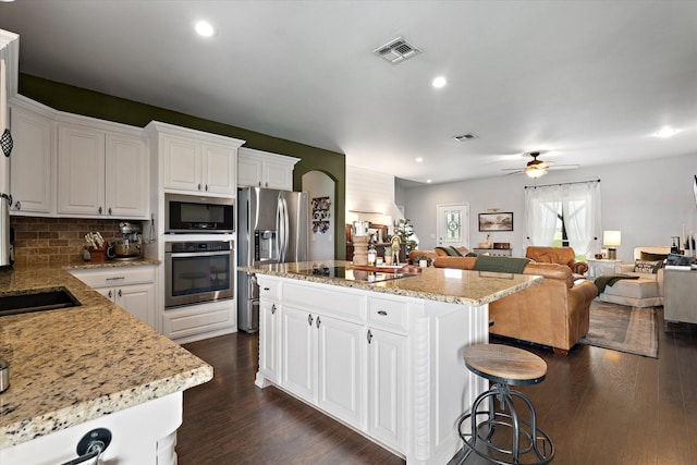 5885 State Highway 160, Whitewright, TX 75491 - kitchen with stainless steel appliances, dark wood-style flooring, a center island, a ceiling fan, and white cabinetry