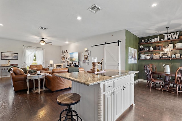 5885 State Highway 160, Whitewright, TX 75491 - kitchen featuring a barn door, black electric stovetop, dark wood-type flooring, and recessed lighting