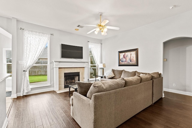 2009 Lake Fork Ct, Denton, TX 76210 - living area with arched walkways, dark wood-style flooring, ceiling fan, and a tile fireplace