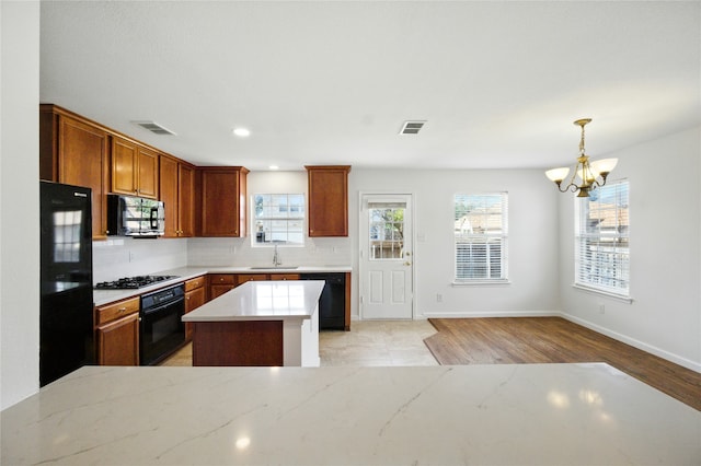 12430 Ridgetop Cir, Frisco, TX 75035 - kitchen featuring black appliances, a chandelier, healthy amount of natural light, light wood finished floors, and recessed lighting