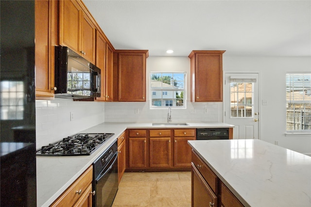 12430 Ridgetop Cir, Frisco, TX 75035 - kitchen with black appliances, plenty of natural light, decorative backsplash, brown cabinets, and recessed lighting
