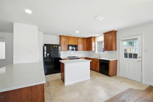 12430 Ridgetop Cir, Frisco, TX 75035 - kitchen featuring black appliances, decorative backsplash, brown cabinetry, a kitchen island, and recessed lighting
