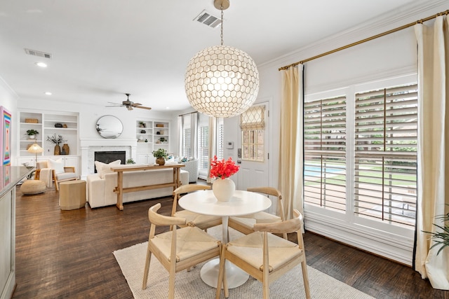 6154 Vickery Blvd, Dallas, TX 75214 - dining area featuring crown molding, dark wood finished floors, a fireplace, a ceiling fan, and built in features