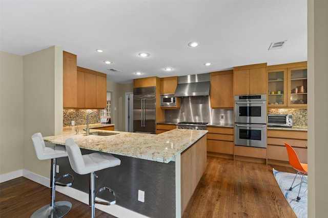 4247 Goodfellow Dr, Dallas, TX 75229 - kitchen with built in appliances, wall chimney exhaust hood, dark wood-style floors, tasteful backsplash, and recessed lighting