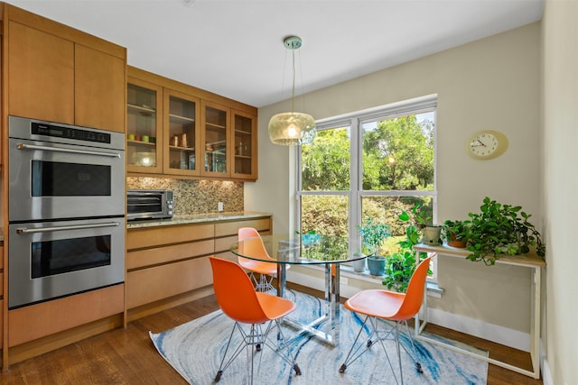 4247 Goodfellow Dr, Dallas, TX 75229 - kitchen with stainless steel double oven, backsplash, dark wood-type flooring, glass insert cabinets, and brown cabinetry