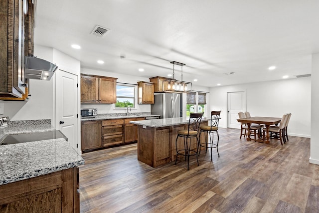 293 Private Road 36008, Honey Grove, TX 75446 - kitchen with stainless steel appliances, exhaust hood, a center island, dark wood-type flooring, and a kitchen bar