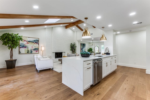 1508 N Waterview Dr, Richardson, TX 75080 - kitchen featuring stainless steel dishwasher, open floor plan, a skylight, white cabinetry, and recessed lighting