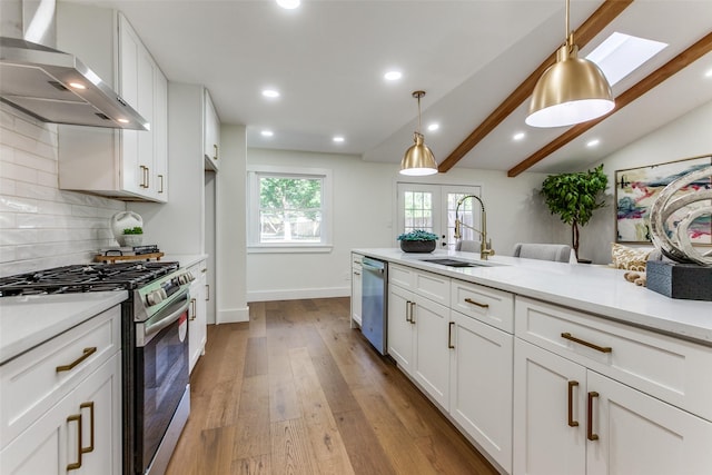 1508 N Waterview Dr, Richardson, TX 75080 - kitchen featuring stainless steel appliances, wall chimney exhaust hood, light countertops, wood finished floors, and white cabinets