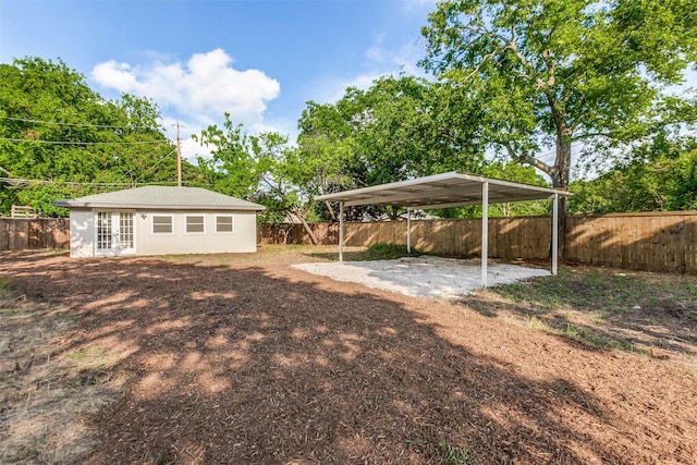 1508 N Waterview Dr, Richardson, TX 75080 - fenced backyard featuring french doors, a detached carport, and dirt driveway