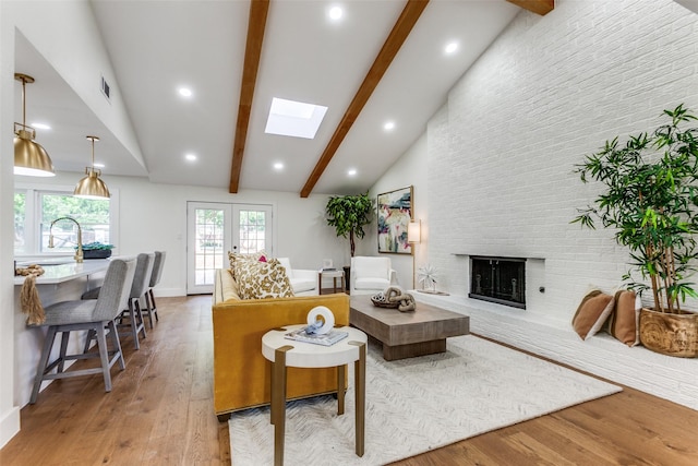 1508 N Waterview Dr, Richardson, TX 75080 - living room featuring a skylight, light wood-style flooring, a brick fireplace, and recessed lighting
