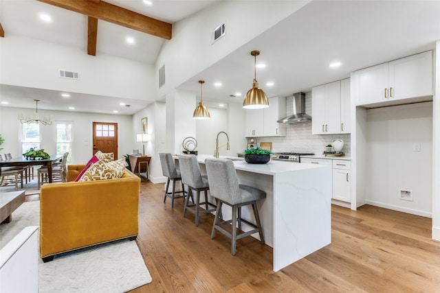 1508 N Waterview Dr, Richardson, TX 75080 - kitchen featuring wall chimney exhaust hood, light countertops, a breakfast bar area, white cabinetry, and recessed lighting