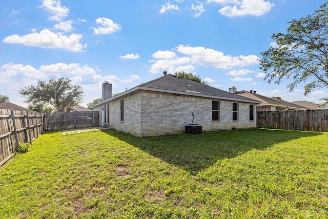 6119 Wall St, Arlington, TX 76018 - back of house with a chimney, a fenced backyard, and brick siding