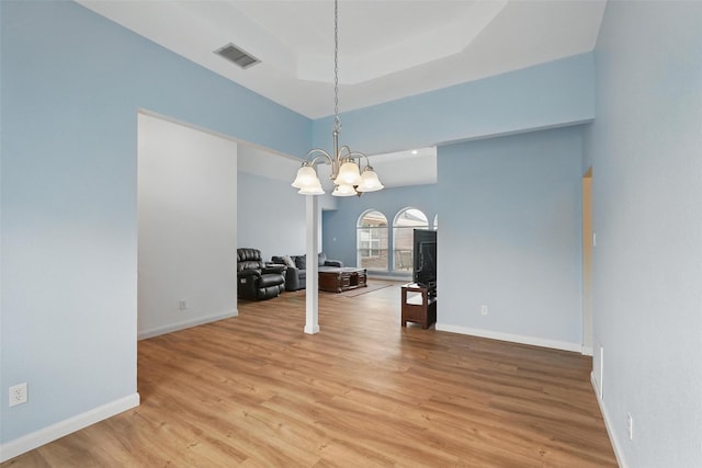 1801 Bent Brook Dr, Mesquite, TX 75181 - empty room featuring a chandelier, light wood-type flooring, and a raised ceiling