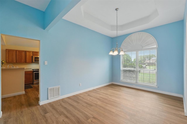 1801 Bent Brook Dr, Mesquite, TX 75181 - empty room with a chandelier, light wood-style flooring, and a tray ceiling