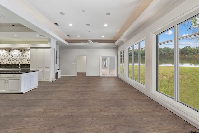 13735 Peninsula Rd, Whitehouse, TX 75791 - unfurnished living room with a water view, a tray ceiling, a ceiling fan, dark wood finished floors, and recessed lighting