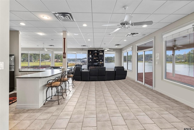 13735 Peninsula Rd, Whitehouse, TX 75791 - living room featuring a ceiling fan, a water view, light tile patterned floors, a paneled ceiling, and recessed lighting