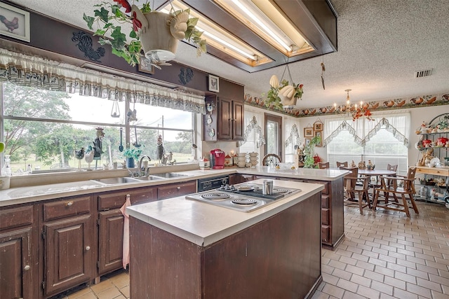 1000 Meadow Hill Rd, Fort Worth, TX 76108 - kitchen with stainless steel electric cooktop, light countertops, a peninsula, a chandelier, and a textured ceiling