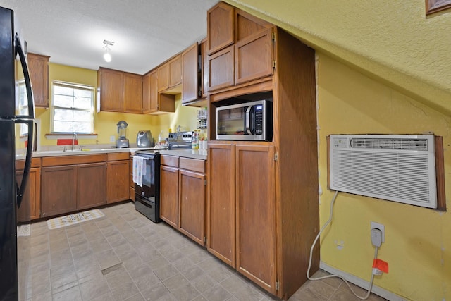 8412 E Fm 917, Alvarado, TX 76009 - kitchen featuring black appliances, light countertops, brown cabinets, a textured ceiling, and a wall unit AC