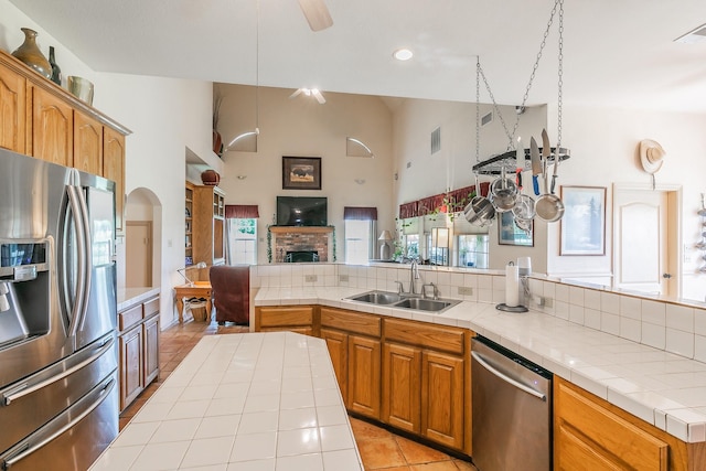3148 Fm 66, Waxahachie, TX 75167 - kitchen with appliances with stainless steel finishes, tile counters, high vaulted ceiling, light tile patterned flooring, and a brick fireplace