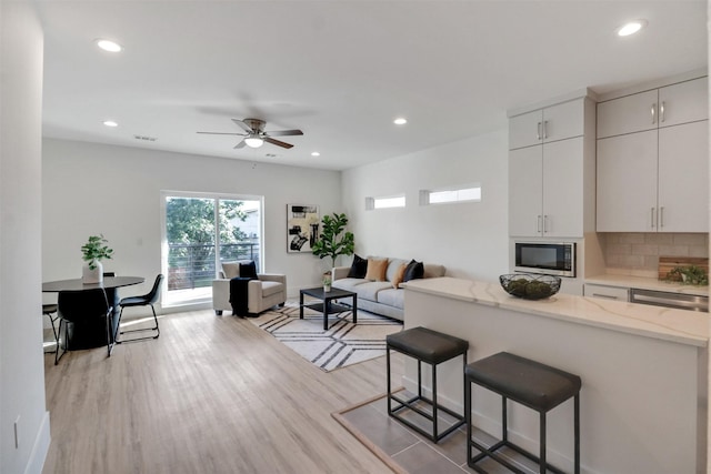 154 S Cisco St, Dallas, TX 75246 - kitchen featuring stainless steel microwave, open floor plan, a breakfast bar, recessed lighting, and ceiling fan