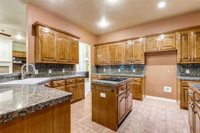 3506 Ash Cir, Richardson, TX 75082 - kitchen featuring decorative backsplash, brown cabinets, dark countertops, black electric cooktop, and a center island