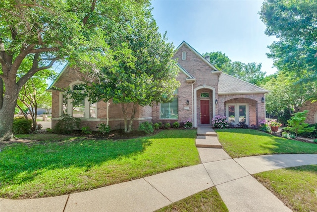 3506 Ash Cir, Richardson, TX 75082 - view of front of house featuring brick siding, a front yard, french doors, and a shingled roof