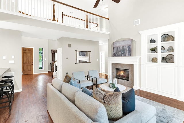 4512 Greenfield Dr, Richardson, TX 75082 - living area with a ceiling fan, wood finished floors, a towering ceiling, and a tiled fireplace