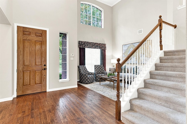 4512 Greenfield Dr, Richardson, TX 75082 - foyer entrance featuring healthy amount of natural light, wood finished floors, stairway, a towering ceiling, and crown molding