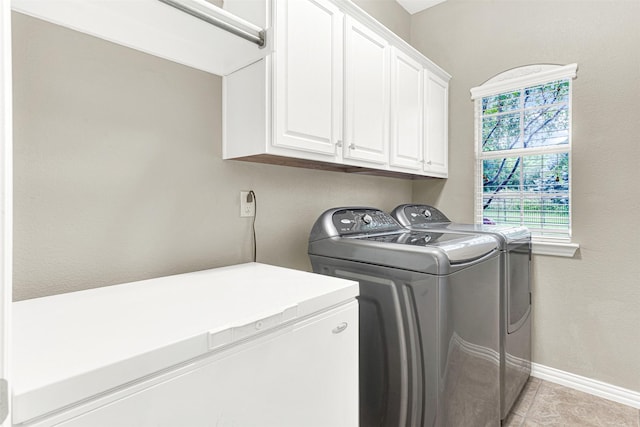 4512 Greenfield Dr, Richardson, TX 75082 - laundry room featuring washing machine and clothes dryer, cabinet space, and light tile patterned floors