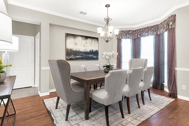 4512 Greenfield Dr, Richardson, TX 75082 - dining room featuring a chandelier, wood finished floors, and crown molding