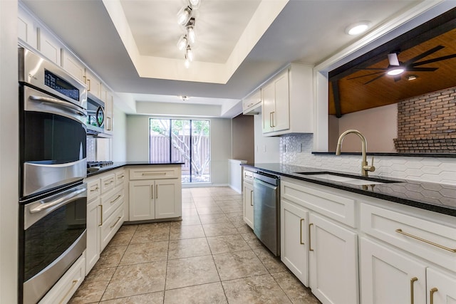 1902 Vassar Dr, Richardson, TX 75081 - kitchen featuring stainless steel appliances, a raised ceiling, a peninsula, tasteful backsplash, and a ceiling fan