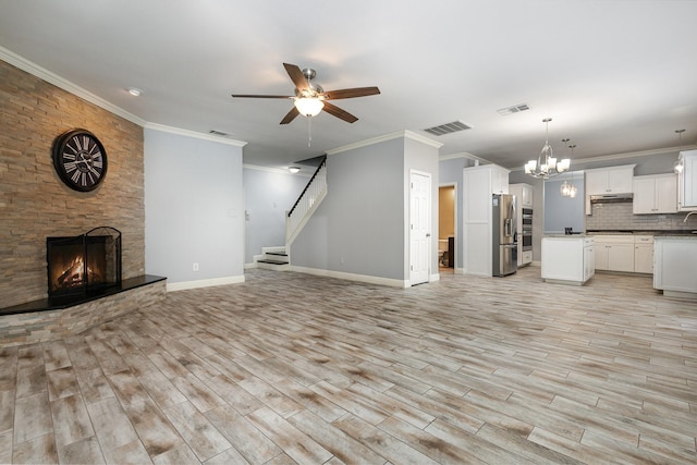 838 Bear Branch Ct, Rockwall, TX 75087 - unfurnished living room featuring ceiling fan, ornamental molding, a fireplace, light wood-type flooring, and a chandelier