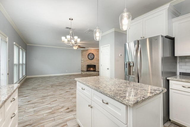 838 Bear Branch Ct, Rockwall, TX 75087 - kitchen featuring a chandelier, ornamental molding, light wood finished floors, a large fireplace, and a kitchen island