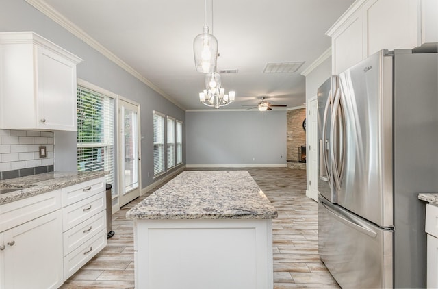 838 Bear Branch Ct, Rockwall, TX 75087 - kitchen featuring stainless steel fridge, ceiling fan, light wood-type flooring, a center island, and ornamental molding