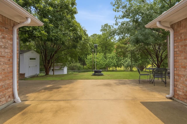 312 Bluffview Ct, Forney, TX 75126 - view of patio / terrace with a shed, outdoor dining space, an outdoor fire pit, and view of scattered trees