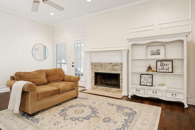 312 Bluffview Ct, Forney, TX 75126 - living room featuring ceiling fan, a tile fireplace, dark wood-type flooring, ornamental molding, and a decorative wall