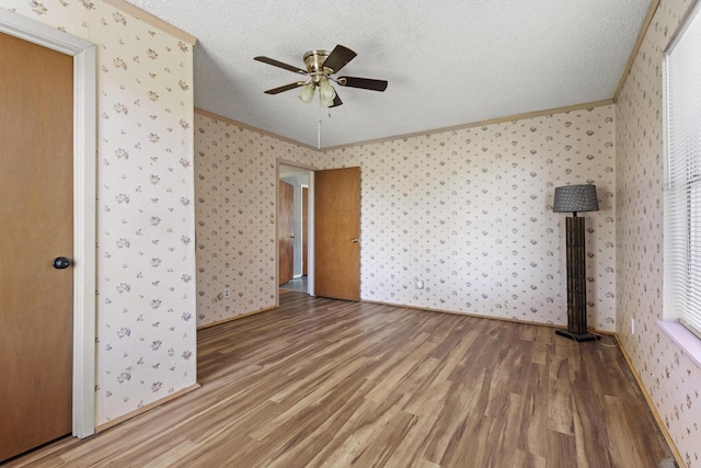 1206 Fm 902, Howe, TX 75090 - unfurnished bedroom featuring wallpapered walls, light wood-type flooring, crown molding, a textured ceiling, and a ceiling fan