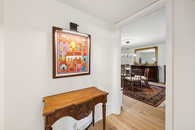 6227 Bandera Ave Unit D, Dallas, TX 75225 - hallway featuring light wood-type flooring and a chandelier